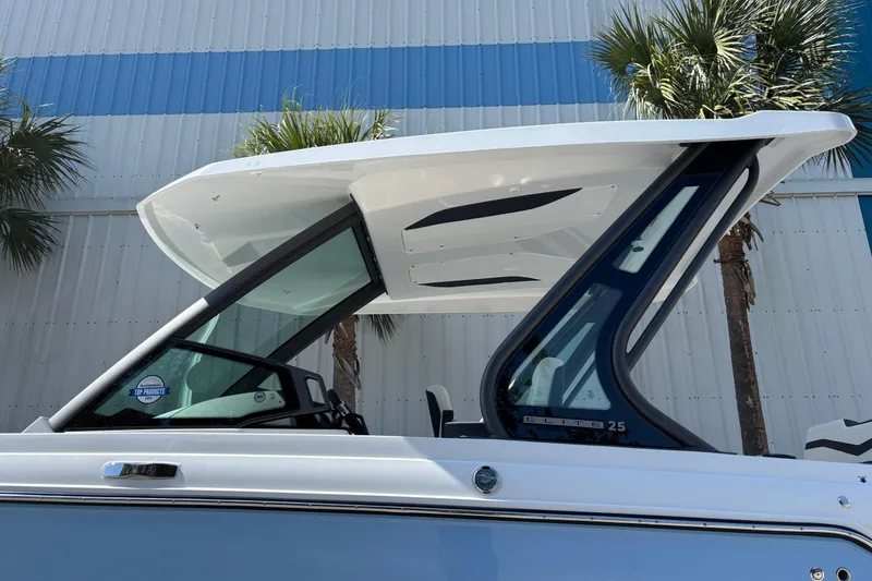 Slide: The Image of 2026 Monterey Elite 25 OB boat with sleek design and modern features, under a clear sky. - 8