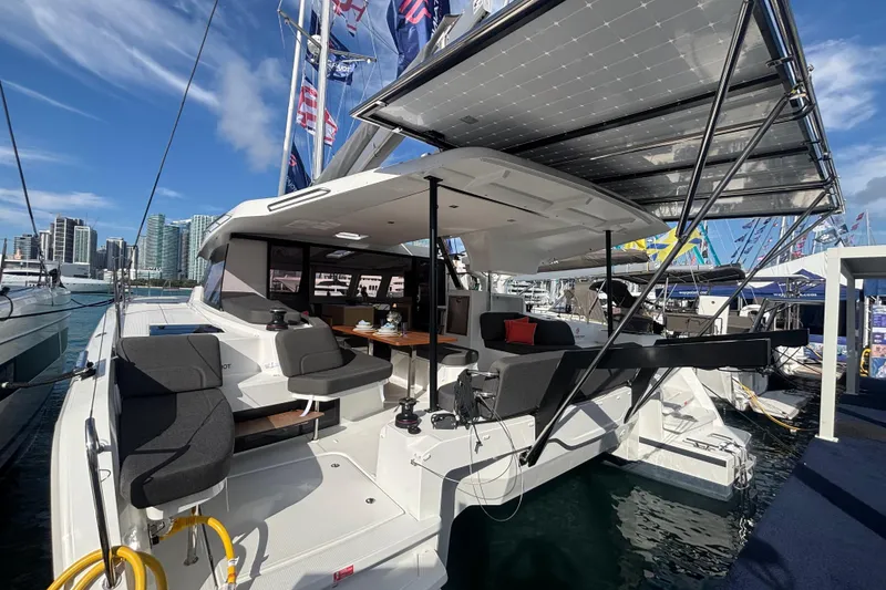Slide: The Image of 2025 Fountaine Pajot 41 catamaran with modern seating and solar panels at a marina. - 11