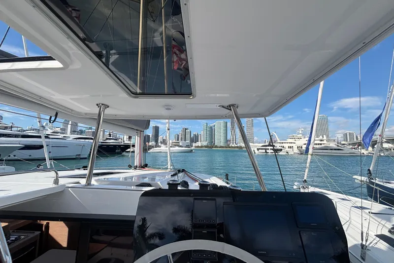 Slide: The Image of 2025 Fountaine Pajot 41 yacht cockpit with city skyline and marina view. - 37