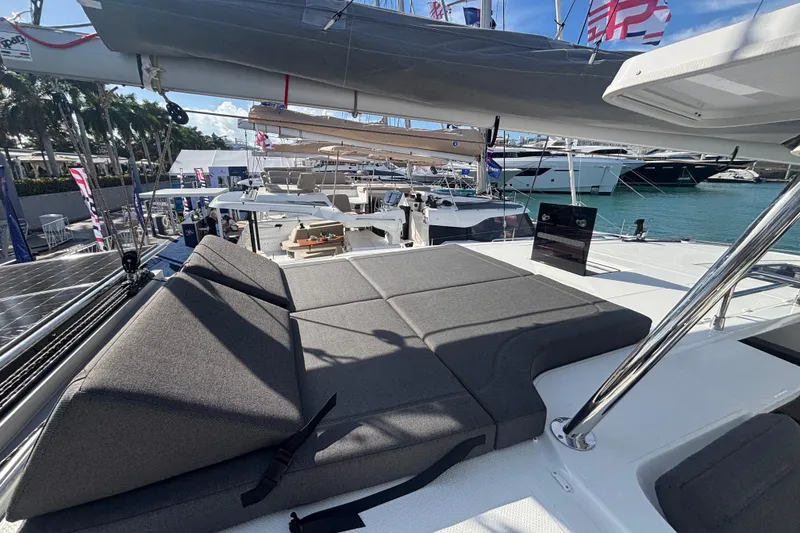 Slide: The Image of 2025 Fountaine Pajot 41 catamaran with sunbathing area, docked at marina. - 41