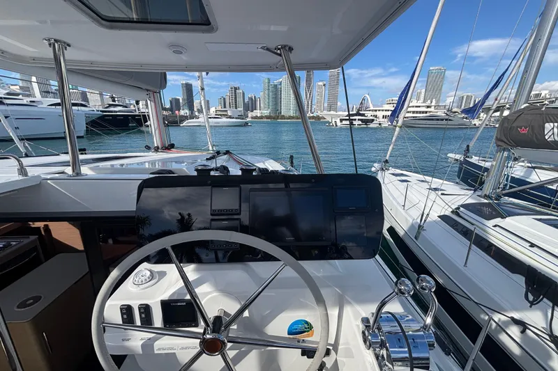 Slide: The Image of Helm of 2025 Fountaine Pajot 41 yacht with city skyline in background. - 7