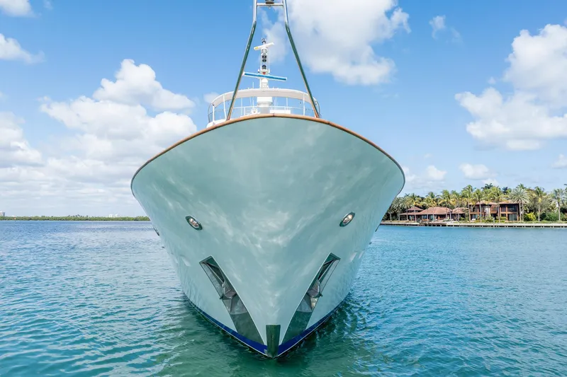 Slide: The Image of Moonen 85 Long Range Cruiser yacht, 1989, on serene blue water with tropical backdrop. - 3