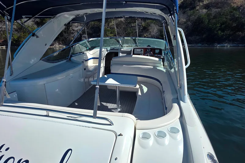 Slide: The Image of 2002 Formula 370 Super Sport boat interior with seating and helm, docked on calm water. - 13
