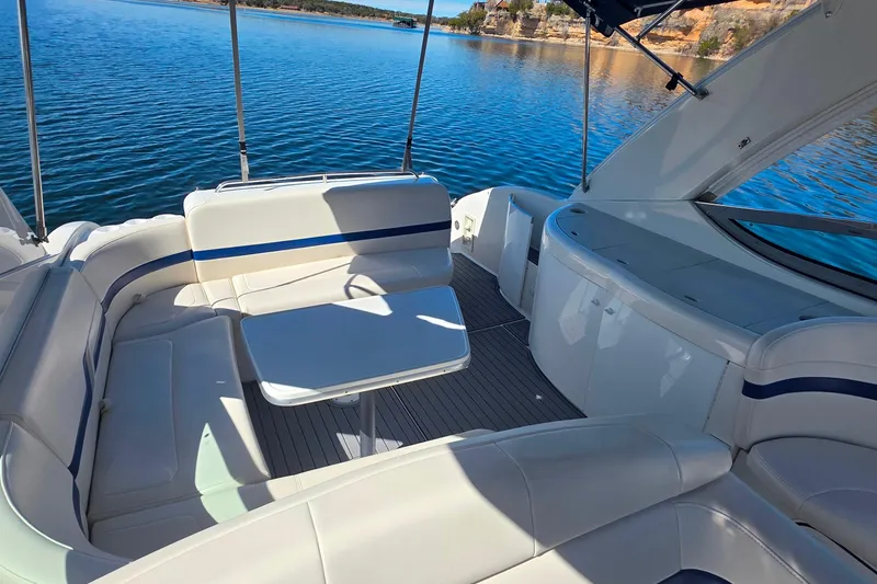 Slide: The Image of 2002 Formula 370 Super Sport boat interior with seating and table on a calm lake. - 16