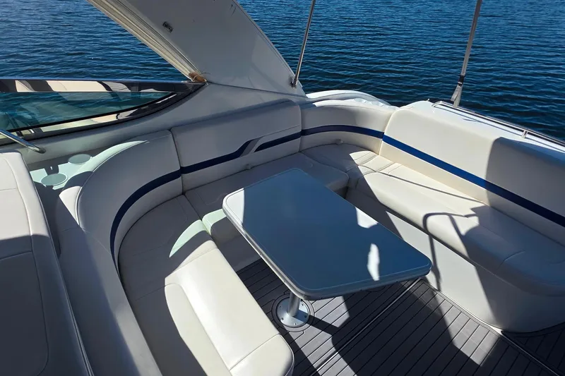 Slide: The Image of 2002 Formula 370 Super Sport boat interior with white seating and table, overlooking water. - 20