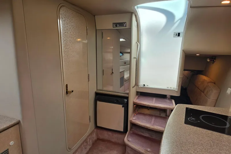 Slide: The Image of Interior of a 2002 Formula 370 Super Sport boat, featuring stairs and compact kitchenette. - 36