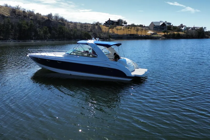 Slide: The Image of 2002 Formula 370 Super Sport boat cruising on a serene lake. - 4