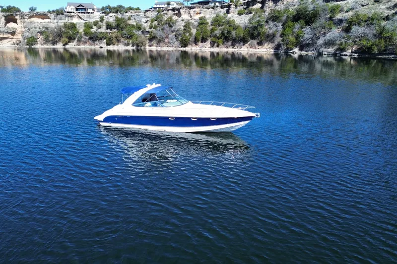 Slide: The Image of 2002 Formula 370 Super Sport boat on a serene lake with rocky shoreline. - 5