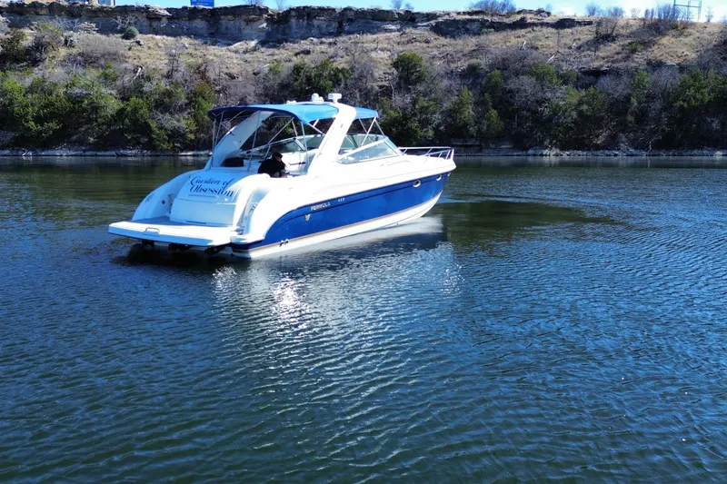 Slide: The Image of 2002 Formula 370 Super Sport boat on a serene lake with scenic background. - 6