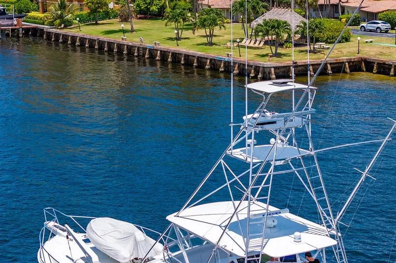 Slide: The Image of 1998 Bertram 60 Convertible yacht docked by a scenic waterfront. - 11