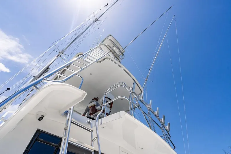 Slide: The Image of 1998 Bertram 60 Convertible yacht against clear blue sky, showcasing sleek design and structure. - 22