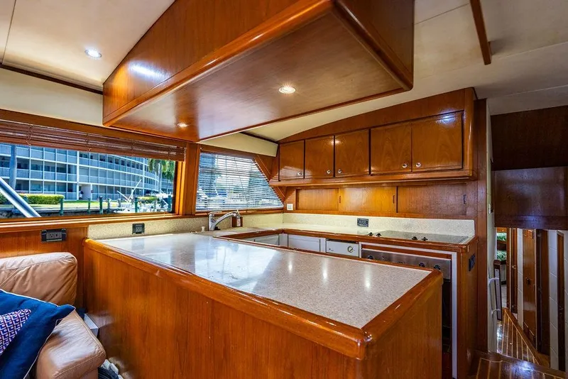 Slide: The Image of Luxurious kitchen interior of a 1998 Bertram 60 Convertible yacht with wooden cabinetry. - 29