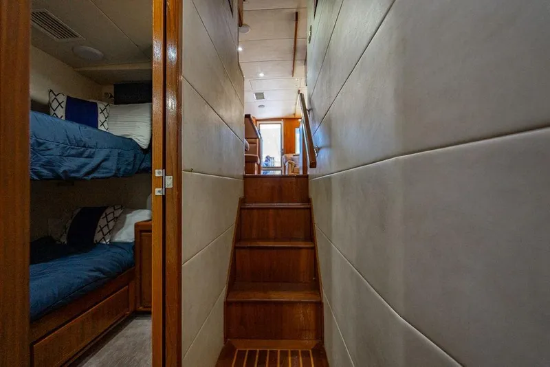 Slide: The Image of Interior of 1998 Bertram 60 Convertible yacht with bunk beds and wooden stairs. - 34