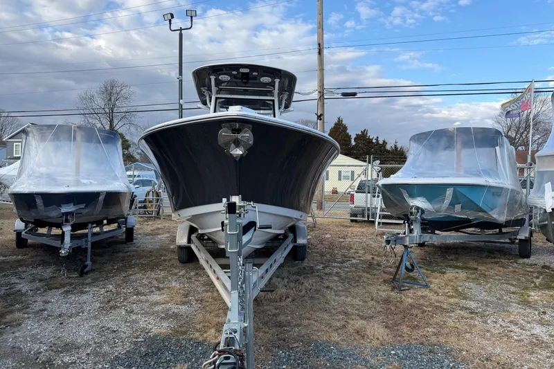 Slide: The Image of 2021 Sportsman Heritage 251 Center Console boat on trailer, flanked by two covered boats. - 2