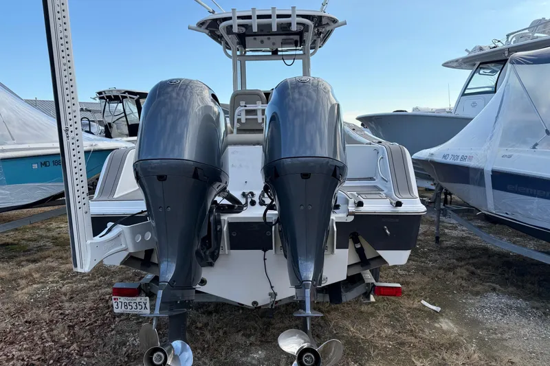 Slide: The Image of 2021 Sportsman Heritage 251 Center Console with dual outboard motors, docked on land. - 5
