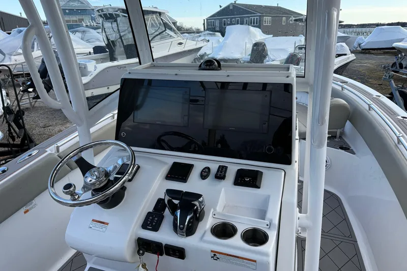 Slide: The Image of 2021 Sportsman Heritage 251 Center Console boat dashboard with steering wheel and controls. - 14