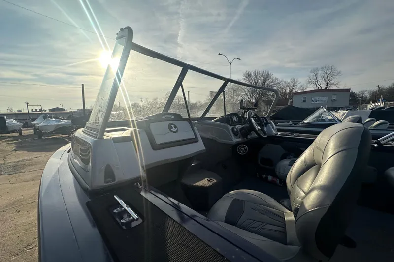 Slide: The Image of 2019 Tracker Targa V-18 Combo boat interior with steering wheel and seats, sunlit background. - 4