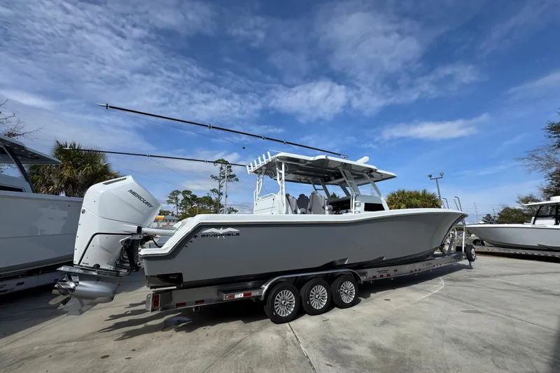Slide: The Image of 2026 Invincible 43 Open Fisherman boat on trailer under blue sky. - 14