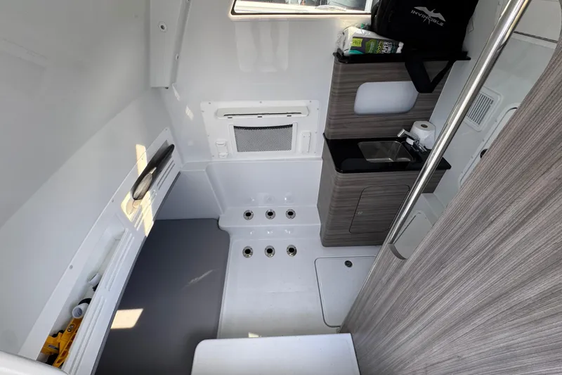 Slide: The Image of Interior of 2026 Invincible 43 Open Fisherman boat, featuring compact sink and storage. - 32
