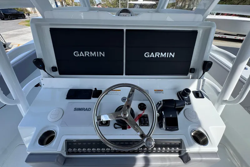 Slide: The Image of 2026 Invincible 43 Open Fisherman helm with dual Garmin displays and Simrad controls. - 43