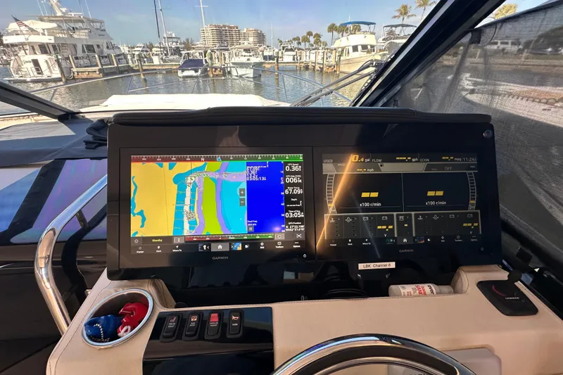 Slide: The Image of 2021 Regal 36 XO yacht dashboard with Garmin navigation system in a marina setting. - 15