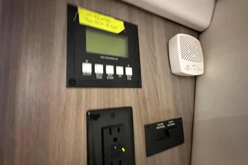 Slide: The Image of Control panel and smoke detector inside 2021 Regal 36 XO boat interior. - 24