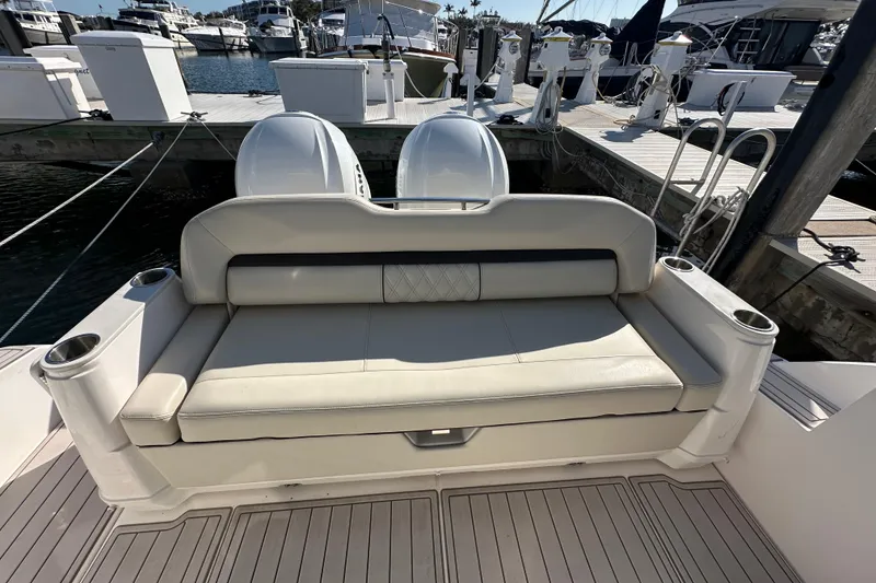Slide: The Image of 2021 Regal 36 XO boat with cushioned seating and twin engines at a marina. - 42