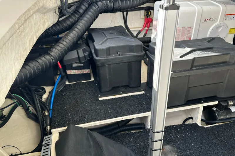 Slide: The Image of Engine compartment of a 2021 Regal 36 XO boat, featuring battery boxes and wiring. - 49