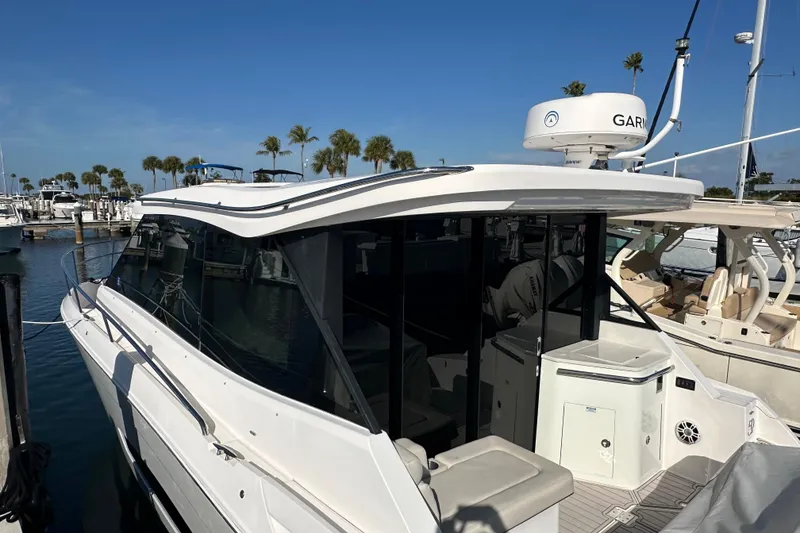Slide: The Image of 2021 Regal 36 XO boat docked at marina with clear blue sky. - 56