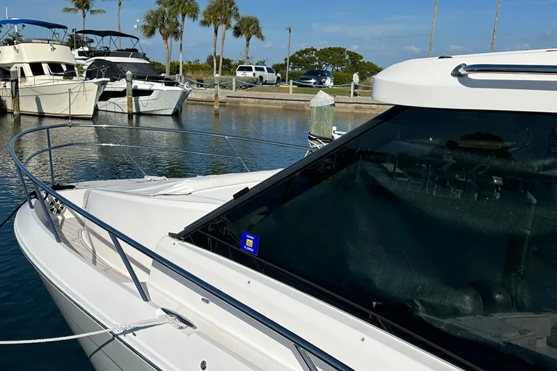 Slide: The Image of 2021 Regal 36 XO yacht docked at marina with palm trees in background. - 58