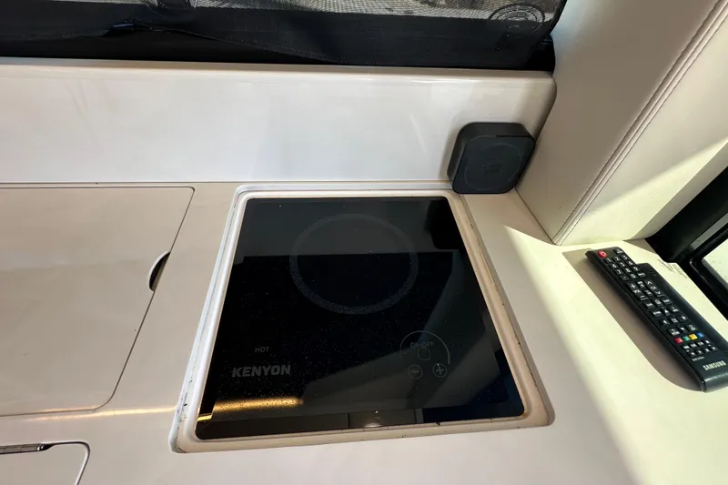 Slide: The Image of 2021 Regal 36 XO yacht interior with Kenyon cooktop and remote control. - 8