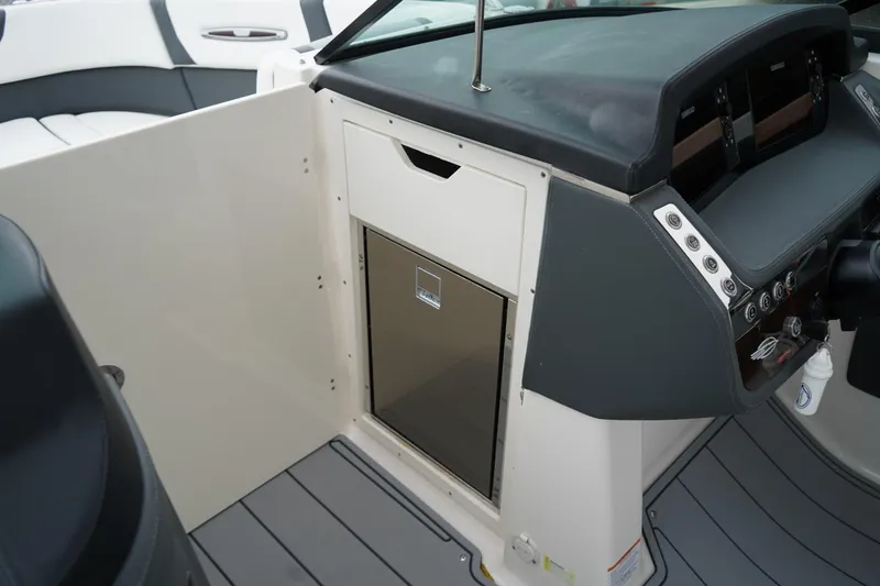 Slide: The Image of 2024 Chaparral 287 SSX boat interior with sleek dashboard and storage compartment. - 14
