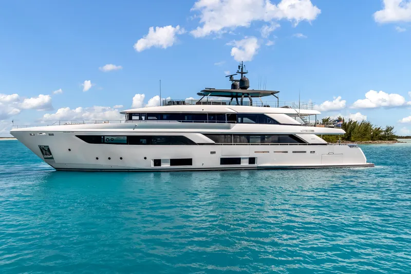 Slide: The Image of Luxurious 2023 Custom Line NAVETTA 42 yacht cruising on clear blue waters. - 2