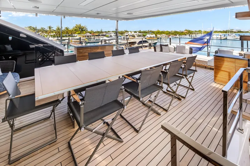 Slide: The Image of Luxurious 2023 Custom Line NAVETTA 42 yacht deck with elegant dining area and marina view. - 53