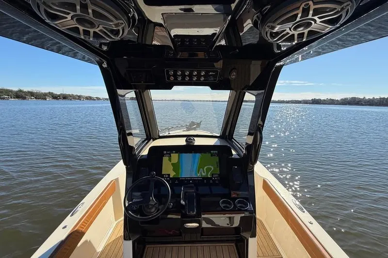 Slide: The Image of 2025 Scout 261 XSS boat interior with navigation system on a sunny day. - 10