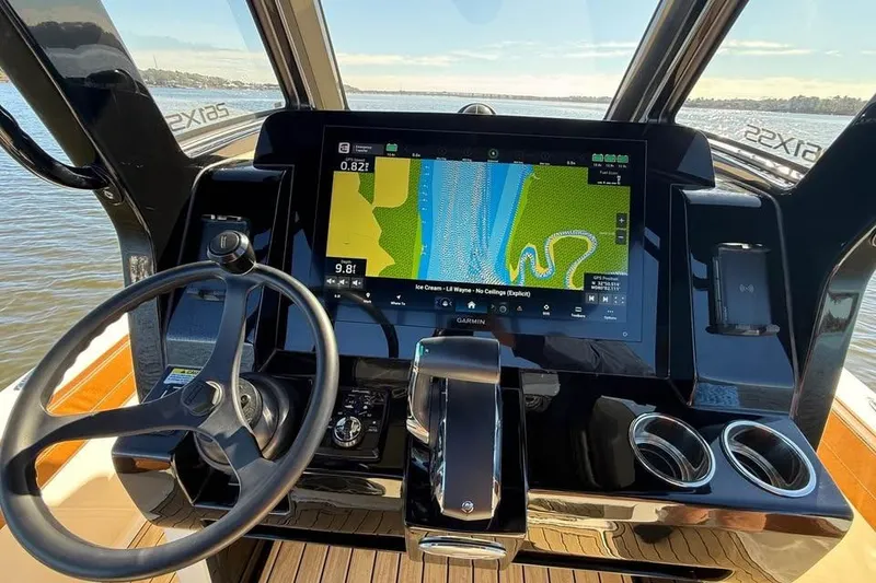 Slide: The Image of 2025 Scout 261 XSS boat dashboard with navigation display and steering wheel. - 11