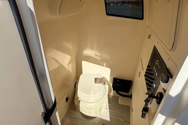 Slide: The Image of 2025 Scout 261 XSS boat interior with toilet and control panel. - 17