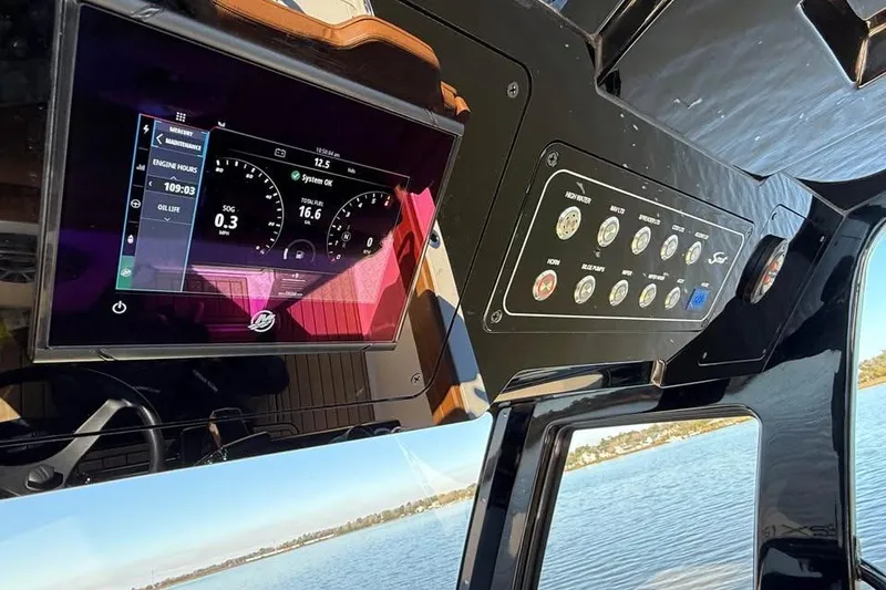 Slide: The Image of 2025 Scout 261 XSS boat dashboard with digital display and control panel. - 18