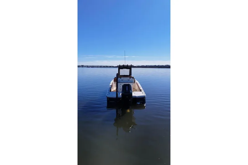 Slide: The Image of 2025 Scout 261 XSS boat on calm water under clear blue sky. - 3