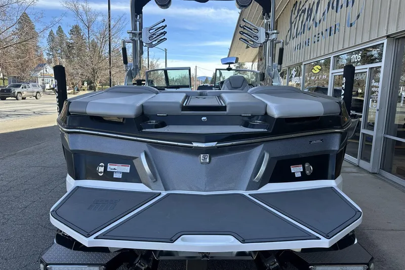 Slide: The Image of 2018 MasterCraft XT22 boat rear view at a marina, showcasing sleek design and features. - 13