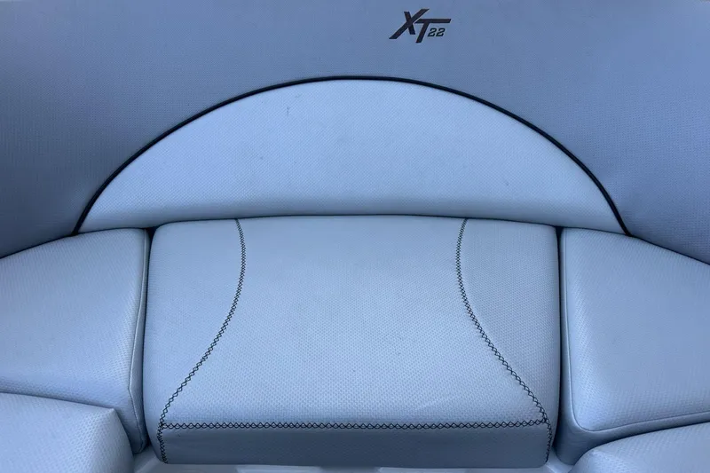 Slide: The Image of 2018 MasterCraft XT22 boat interior seating with elegant stitching and logo. - 4