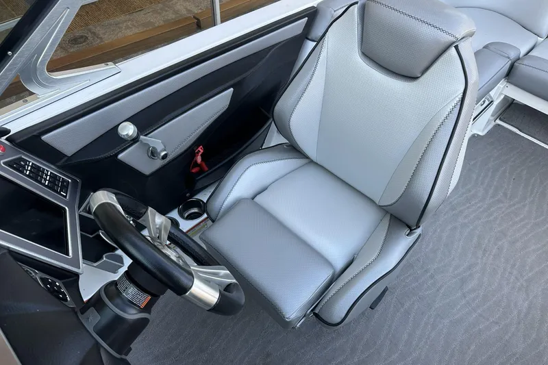 Slide: The Image of 2018 MasterCraft XT22 boat interior with sleek steering and modern seating. - 8