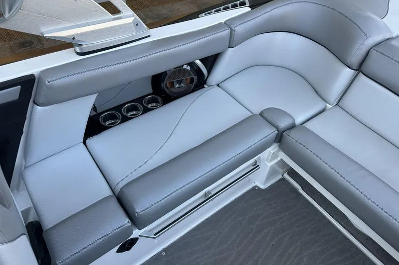 Slide: The Image of 2018 MasterCraft XT22 boat interior with gray seating and cup holders. - 9