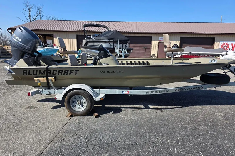 The Image of 2011 Alumacraft MV 1860 AW SC boat on trailer, parked outdoors. - 3