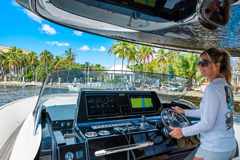 Slide: The Image of Woman steering 2024 Solaris Power 44 Open yacht, vibrant tropical backdrop. - 10