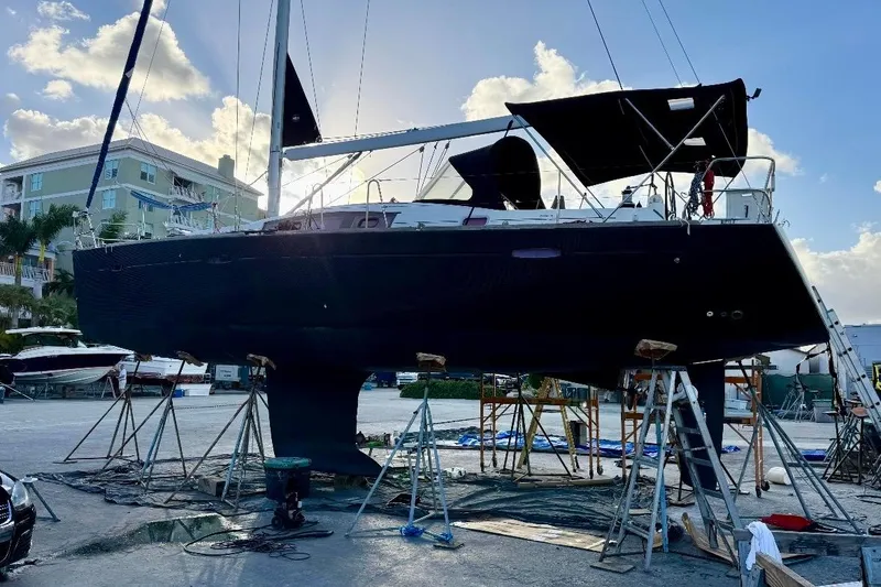 Slide: The Image of 2009 Beneteau Oceanis 43 sailboat on dry dock, silhouetted against a bright sky. - 2