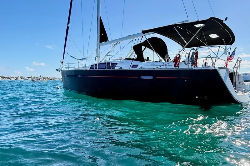 The Image of 2009 Beneteau Oceanis 43 sailboat on clear blue water, sunny day, black hull. - 6
