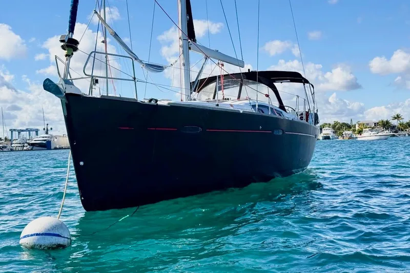 Slide: The Image of 2009 Beneteau Oceanis 43 sailboat anchored in clear blue water under a sunny sky. - 8