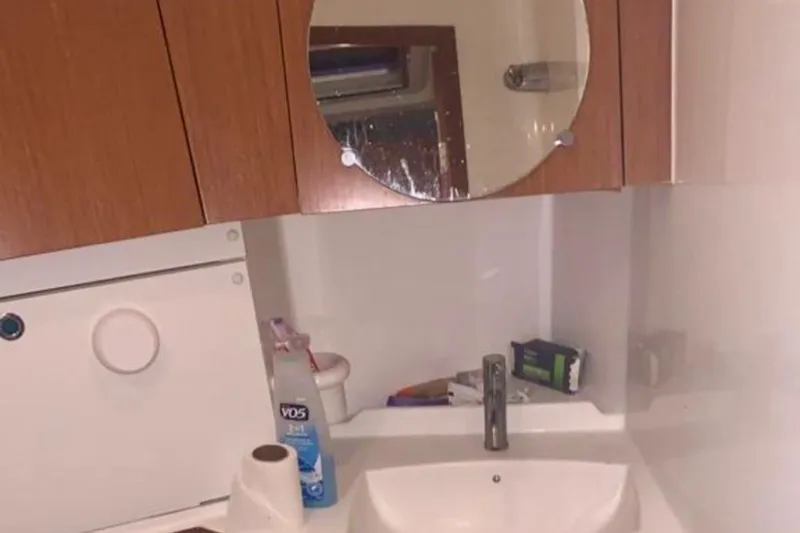 Slide: The Image of Bathroom sink area on a 2009 Beneteau Oceanis 43 yacht, featuring a mirror and storage. - 95