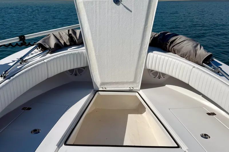 Slide: The Image of 2019 Aquasport 244 Bay boat interior with open storage compartment on calm water. - 12